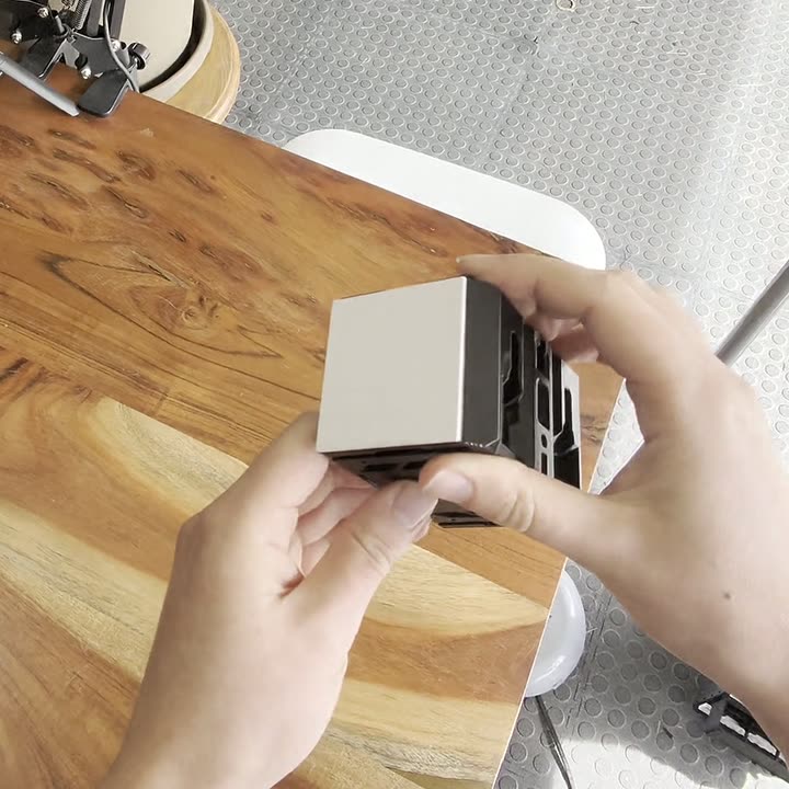 Video: two hands hold a white side cover against the side wall of a small black case, press it in and slide it down until it seats, then slide it up and lift it off again